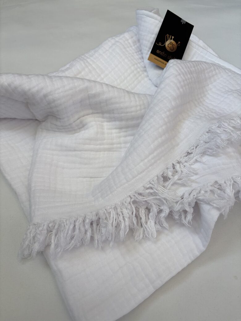 Kristību sedziņa no balta muslīna auduma ar bārkstīm.